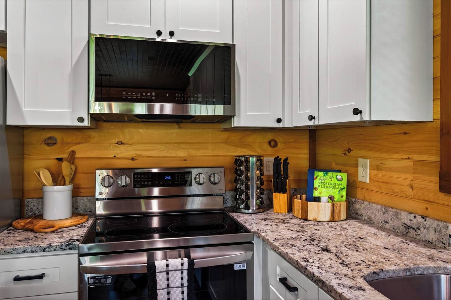 A kitchen with white cabinets, a stainless steel stove, and a microwave.