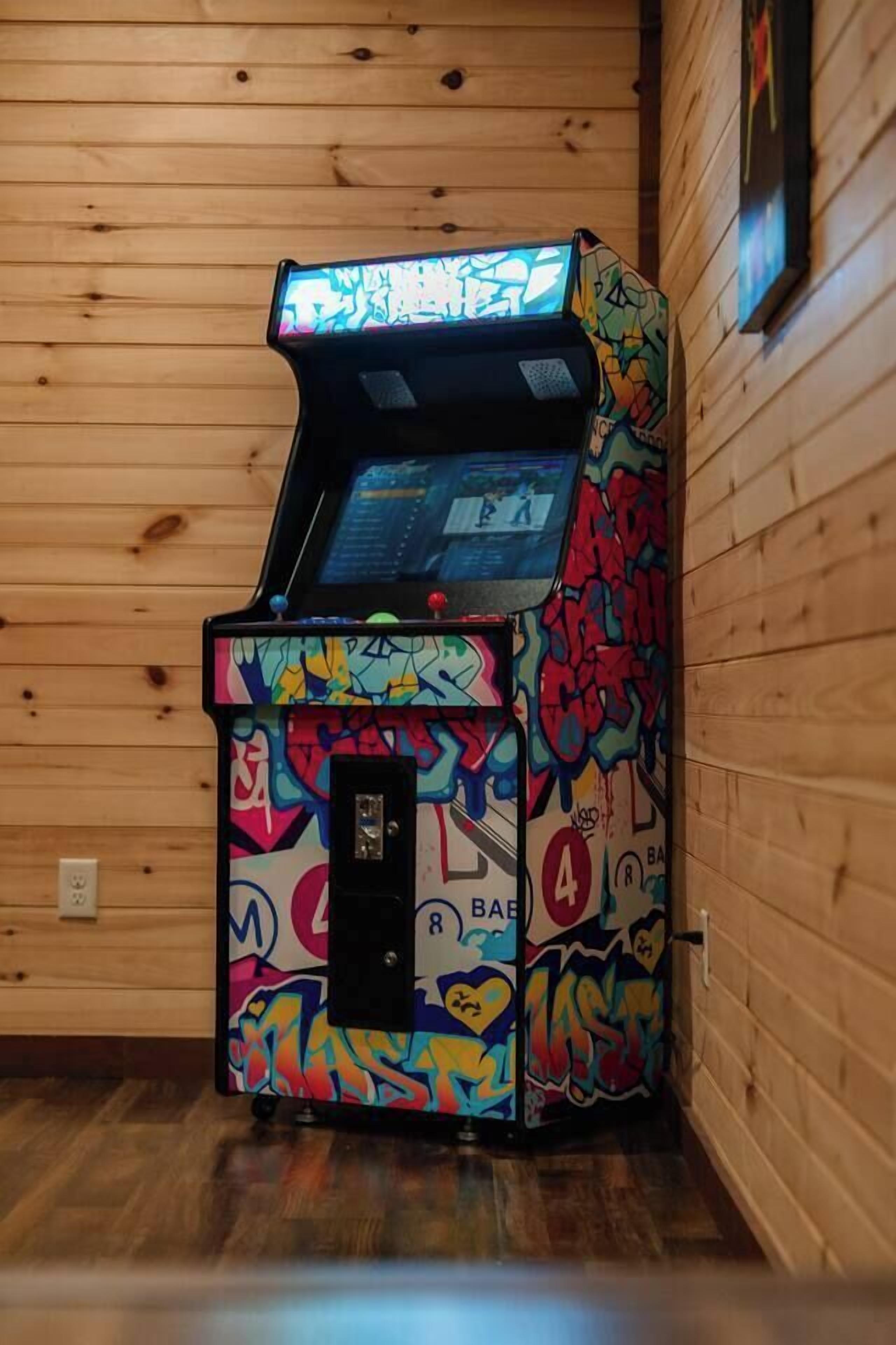 Una máquina recreativa colorida con grafitis en una habitación de madera.