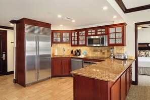 A modern kitchen with a stainless steel refrigerator, a microwave, and a granite countertop. - Waipouli Beach Resort H303 Ocean View 2 BD 3 BA (Kapaa)
