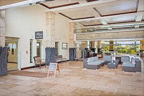 A spacious lobby with a reception desk, seating area, and a view of the outdoors. - Waipouli Beach Resort H303 Ocean View 2BD/3BA SEPT/OCT SPECIAL (Kapaa)