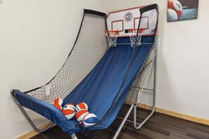 Ein Basketballkorb mit Netz, eine blaue Rutsche und mehrere Basketballbälle.