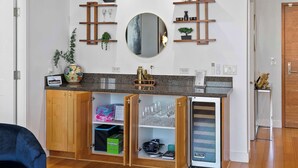 Een moderne keuken met houten kastjes, een inbouwkoelkast en een aanrecht met een vaas en een plant.