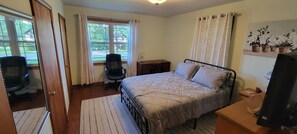 A bedroom with a bed, a desk, a chair, and a window with curtains. - Perfect 3-bedroom house with AC in charming Oil City (Oil City)