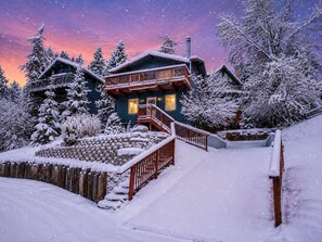 A wooden cabin with a balcony, surrounded by snow-covered trees. - The Moonridge Escape - Walk to Slopes • Cozy Cabin • Fireplace + Private Deck (Big Bear Lake)
