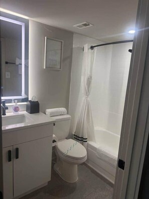 A bathroom with a toilet, sink, and shower area. - New Amazon HQ Pentagon Fashion Centre (Arlington)