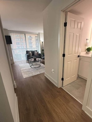 A hallway leading to a living area with a sofa and a coffee table. - New Amazon HQ Pentagon Fashion Centre (Arlington)