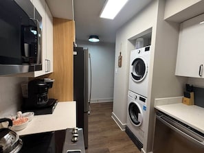 Cocina compacta con microondas, cafetera y lavadora.