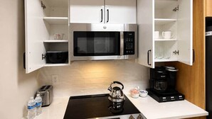 A compact kitchen with a microwave, kettle, toaster, and coffee maker. - New Amazon HQ Pentagon Fashion Centre (Arlington)