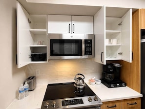 A compact kitchen with a microwave, kettle, toaster, and coffee maker. - New Amazon HQ Pentagon Fashion Centre (Arlington)