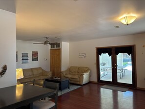 A living room with a dining table, two sofas, a ceiling fan, and a door leading outside. - Charming 2-bedroom house near Clearwater Lake and the Black River (Piedmont)