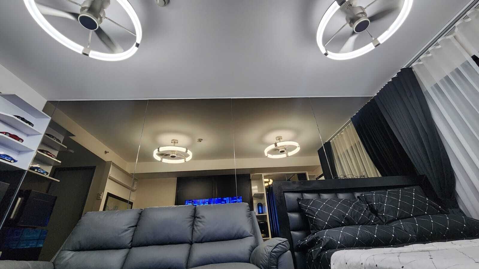 Una habitación moderna con una cama, una zona de estar y un televisor.