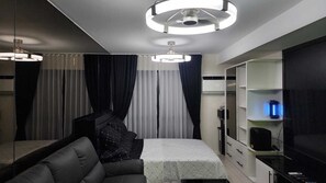 Ein modernes Schlafzimmer mit einem Bett, einem Kleiderschrank, einem Spiegel und einer Deckenleuchte.