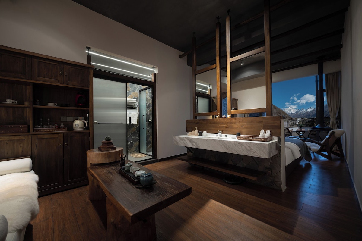 A modern interior with a wooden floor, a marble countertop sink, and a stone wall.