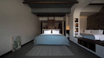 Un dormitorio moderno con una cama grande, una alfombra gris y una pared de piedra.