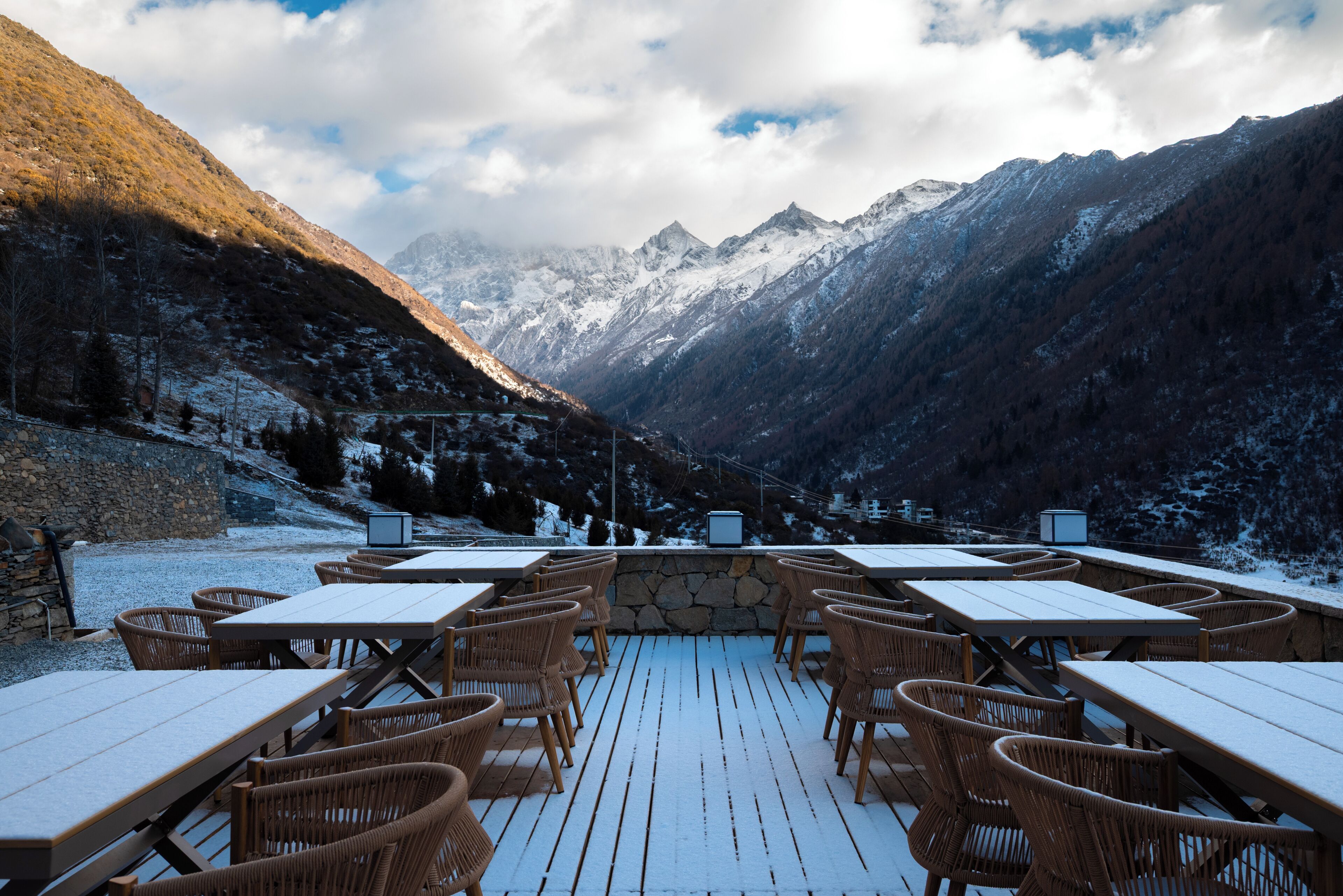 Un restaurante con terraza al aire libre y vistas a un paisaje montañoso.