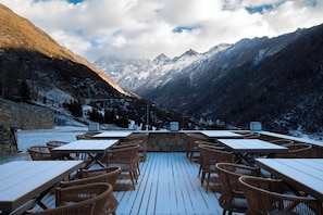 Un restaurant doté d’une terrasse offrant une vue sur un paysage montagneux.