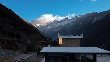 A mountain view with a stone building featuring a sign.