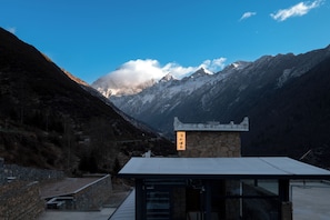 Une vue sur la montagne avec un bâtiment en pierre sur lequel on peut voir une enseigne.
