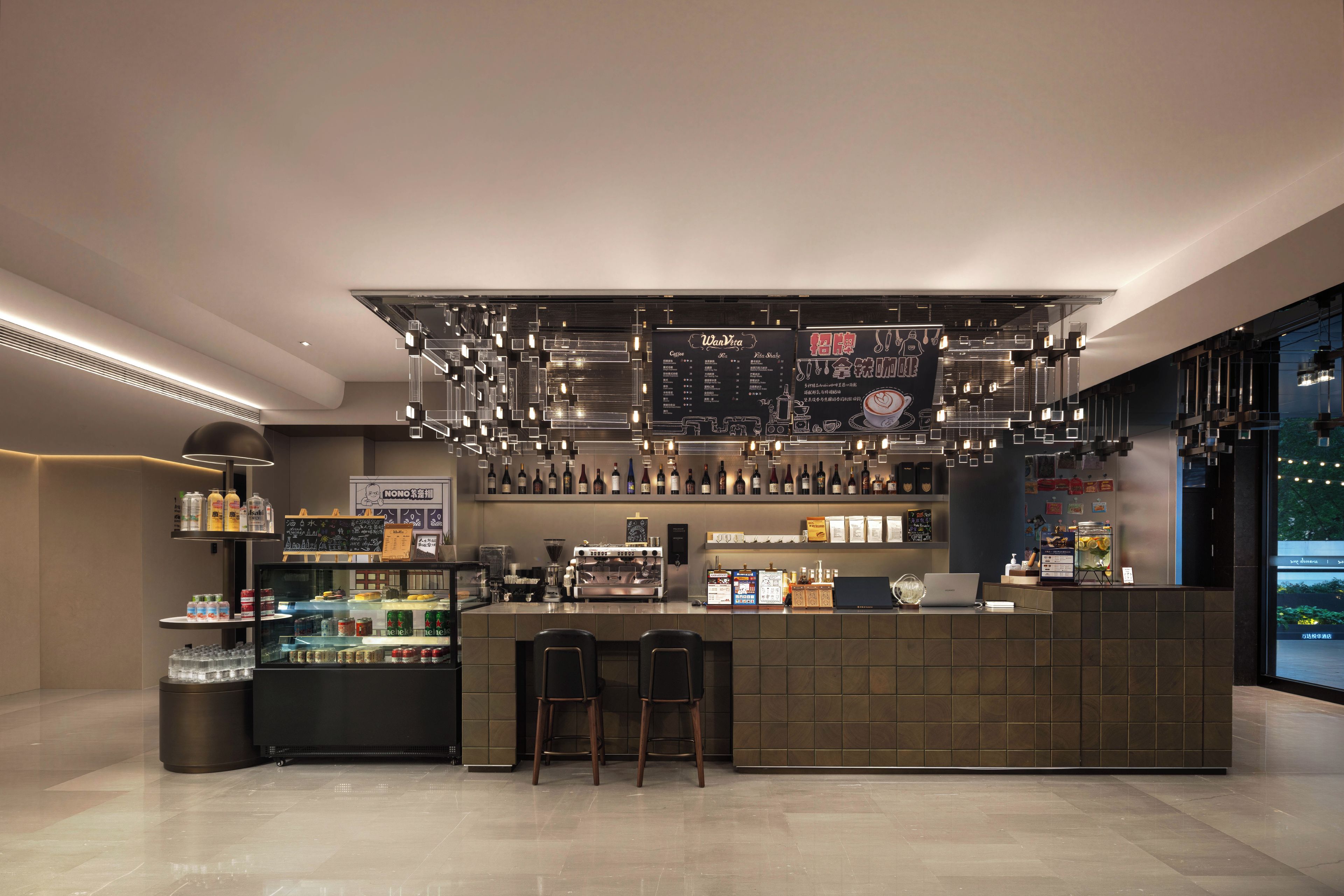 Un espace bar moderne doté d’un comptoir, de sièges et offrant un large choix de boissons.