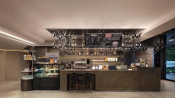 Uma área de bar moderna com balcão, assentos e diversas bebidas.