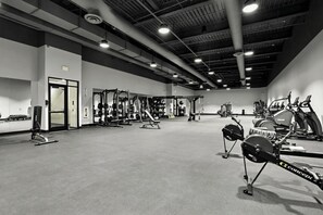 Ein Fitnessstudio mit verschiedenen Trainingsgeräten, darunter Kraftgeräte, Laufbänder und Ergometer.