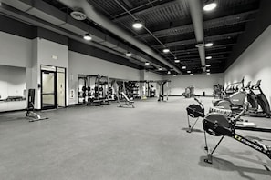 Ein Fitnessstudio mit verschiedenen Trainingsgeräten, darunter Kraftgeräte, Laufbänder und Ergometer.