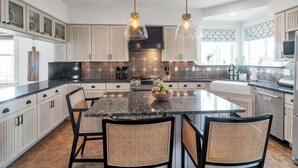 A modern kitchen with a central island, pendant lighting, and a dining area with chairs. - Beautiful Ranch with Hot Tub Near Mt.Princeton Hot Springs (Nathrop)