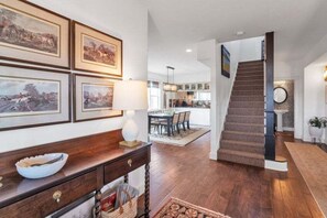 A modern interior with a staircase leading to a dining area, wooden flooring, and framed artwork on the walls. - Beautiful Ranch with Hot Tub Near Mt.Princeton Hot Springs (Nathrop)