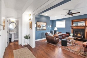 A spacious living room with a fireplace, comfortable seating, and a large window. - Beautiful Ranch with Hot Tub Near Mt.Princeton Hot Springs (Nathrop)