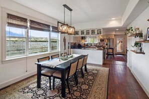 A spacious kitchen with a dining area, large windows, and a view of the outdoors. - Beautiful Ranch with Hot Tub Near Mt.Princeton Hot Springs (Nathrop)