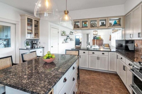 A kitchen with a granite countertop, white cabinets, and a bowl of fruit. - Beautiful Ranch with Hot Tub Near Mt.Princeton Hot Springs (Nathrop)