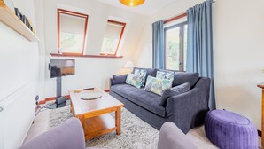 A modern living room with a sofa, coffee table, and a television.