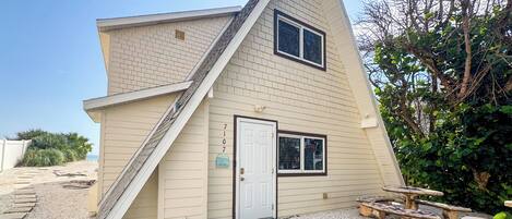 A house with a sloped roof, a front door, and a small porch area.