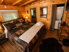 A cozy cabin-style room with a bed, a desk, and a refrigerator. - Lake Harmony retreat with hot tub, sauna, game room, and ski access (Lake Harmony)