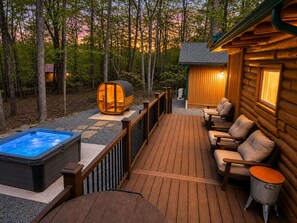 A wooden deck with a hot tub, seating area, and a cylindrical structure. - Lake Harmony retreat with hot tub, sauna, game room, and ski access (Lake Harmony)