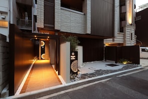 A modern building entrance with a sign reading 'Entrance' and a decorative sign for 'Kakidō in Hiroshima'. - Kaleido inn Hiroshima (Hiroshima)