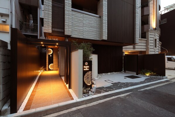 A modern building entrance with a sign reading 'Entrance' and a decorative sign for 'Kakidō in Hiroshima'. - Kaleido inn Hiroshima (Hiroshima)
