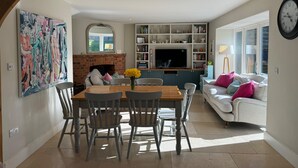 Un comedor con chimenea de ladrillo, televisor y estantería.