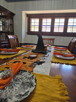 A dining table set with plates, napkins, and a decorative pumpkin centerpiece. - 1910 Beautiful Craftsman Style Home (Topeka)