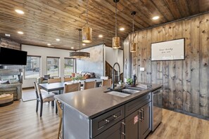 A modern kitchen with a central island, wooden ceiling, and pendant lighting. - New Host Special • Indoor Pool • Glow Court • Golf Sim • Rooftop Hot Tub • Sauna (Pigeon Forge)