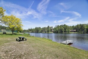 A lakeside picnic area with a dock and a house in the background. - Cozy Fall Foliage Retreat: Hot Tub, Firepit, Hikes, Lakes, and Indoor Waterparks (Blakeslee)