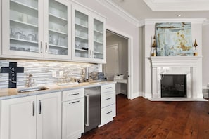 A kitchen with white cabinetry, a stainless steel dishwasher, and a tiled backsplash.
