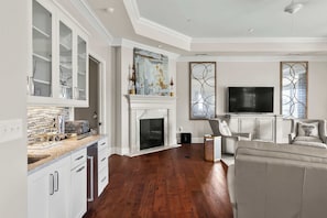 A spacious living room with a fireplace, a television, and a seating area.