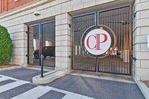 En bygningseingang med en portindkørsel og et stort, rundt skilt med bogstaverne 'CP'.