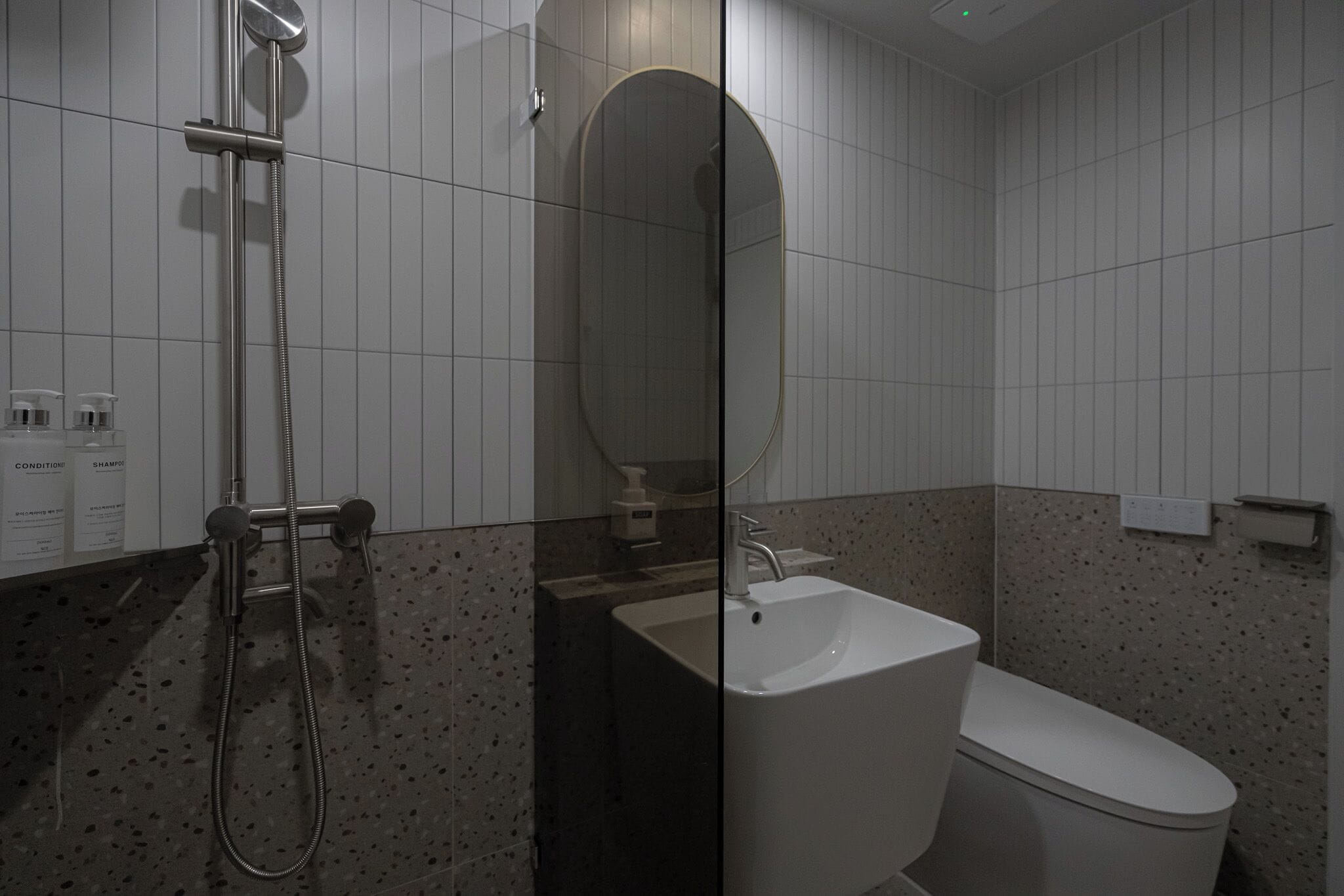 A modern bathroom with a shower, sink, and toilet.
