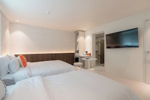 A modern hotel room with two beds, a small table, a TV, and a shower area. - Leclerc (Ulsan)