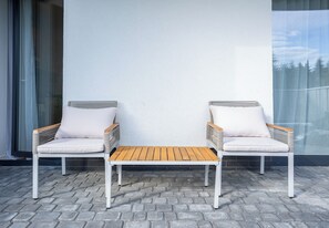 Two white chairs with wooden slats and cushions, a small wooden table, and a white wall with a window. - Rymanowska Chic Apartment (Rzeszów)