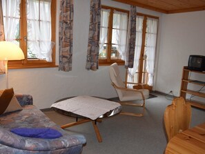 A cozy room with a sofa, a chair, a small table, and a television. - Favre OG Ost Appartement/Fewo, Dusche oder Bad, WC, 1 Schlafraum 2-Bett-Wohnung by Interhome (Matten  (St. Stephan))