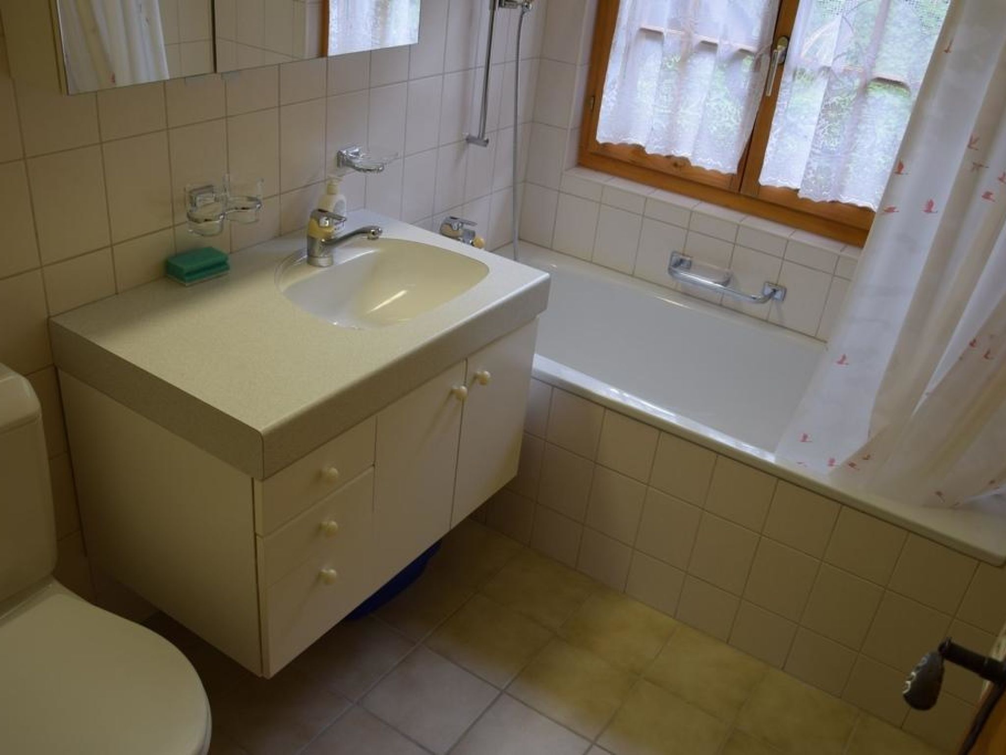 Kylpyhuone, jossa on pesuallas, peili, wc ja kylpyamme.