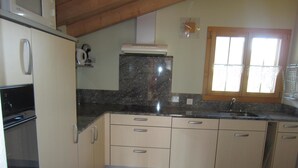 A kitchen with a built-in oven, a microwave, a sink, and cabinets. - Morgenstern Appartement/Fewo, Dusche, WC, 1 Schlafraum 4-Bett-Wohnung by Interhome (St Stephan)